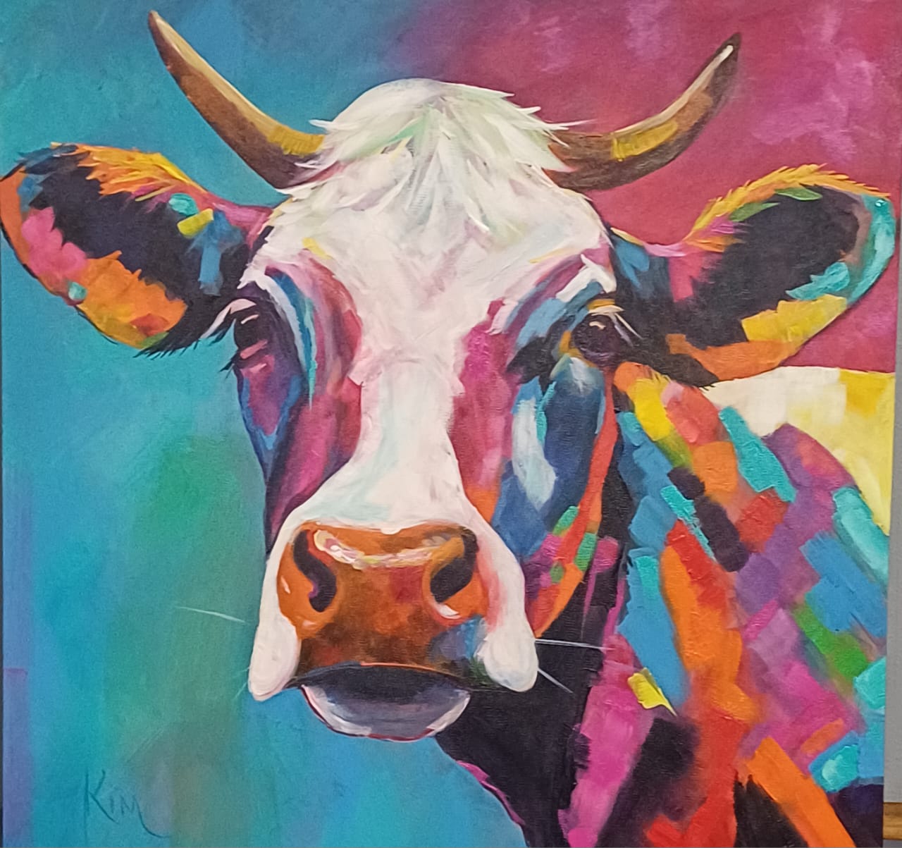 Original painting of a cow in multi-coloured patches on pink and teal by Kim Bezuidenhout