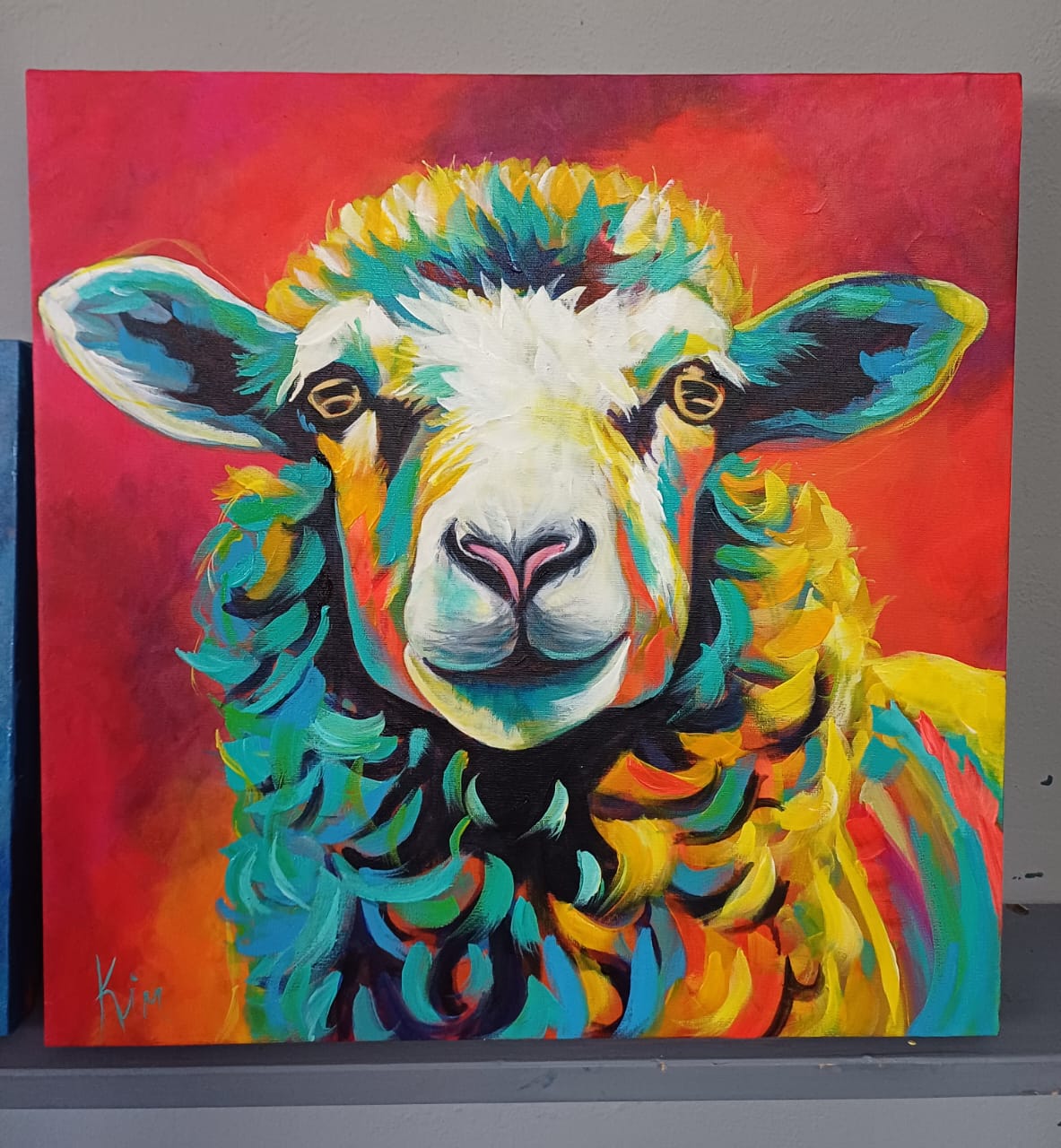 Original painting of a sheep with turquoise and yellow wool on red by Kim Bezuidenhout